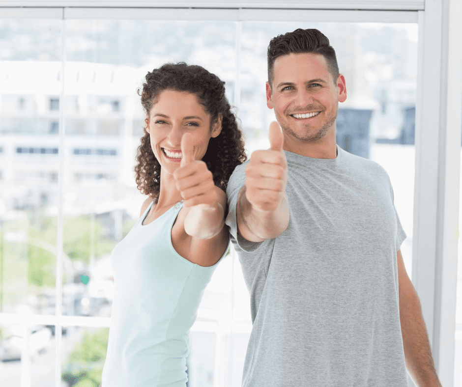 A man and woman giving thumbs up to the camera.