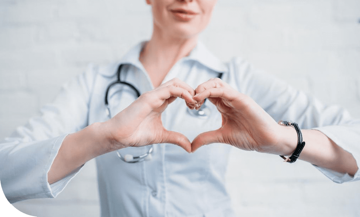 A woman in white shirt making heart with hands.